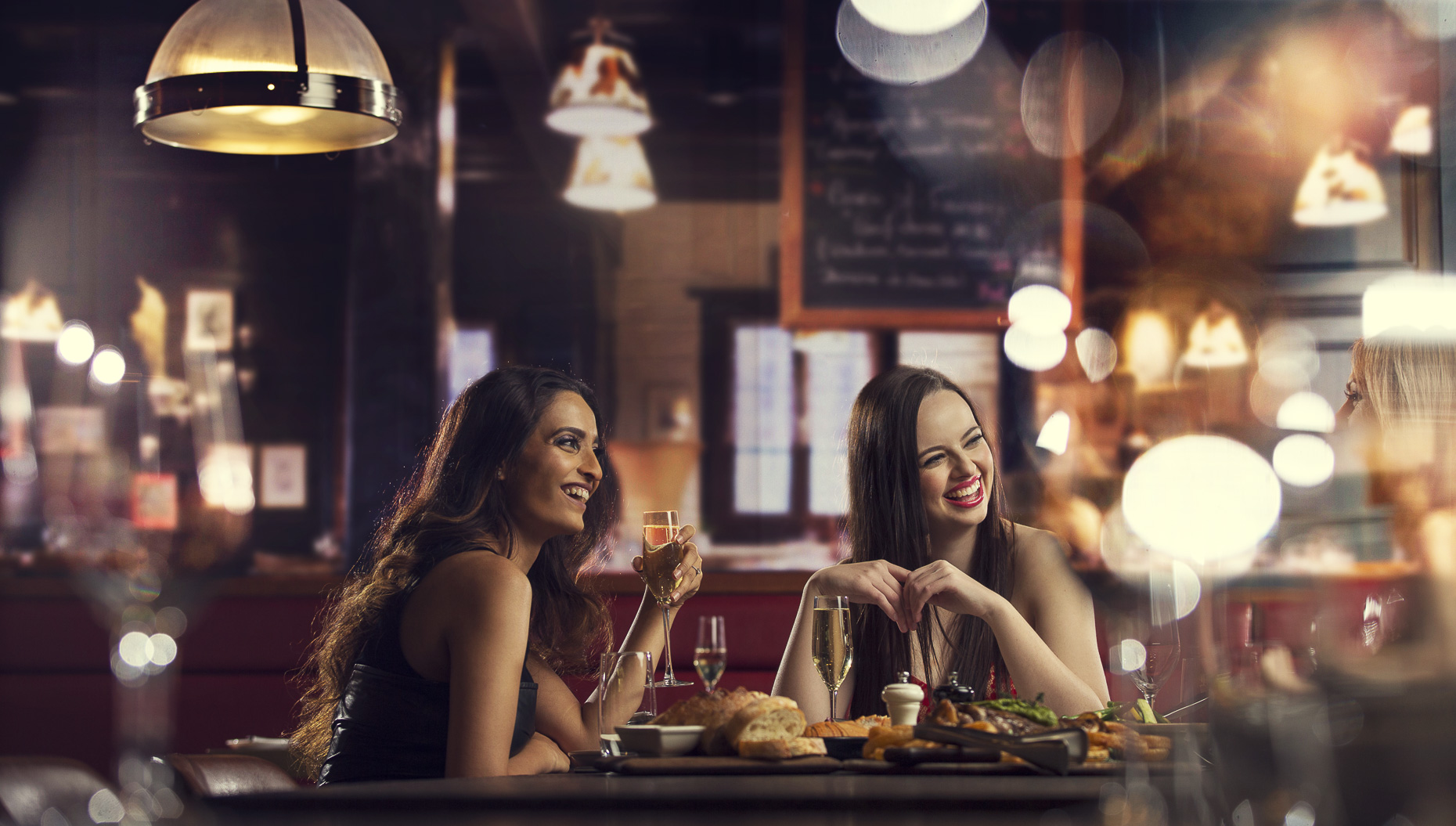 A group of young women enjoying dinner at a high end restaurant